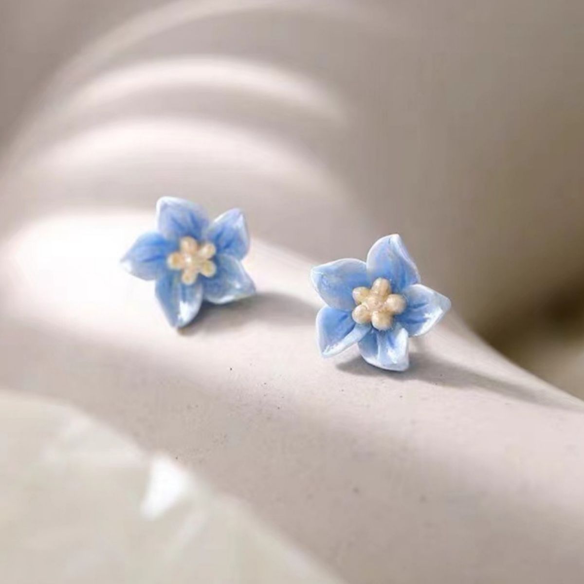 Small floral stud earrings with delicate resin petals