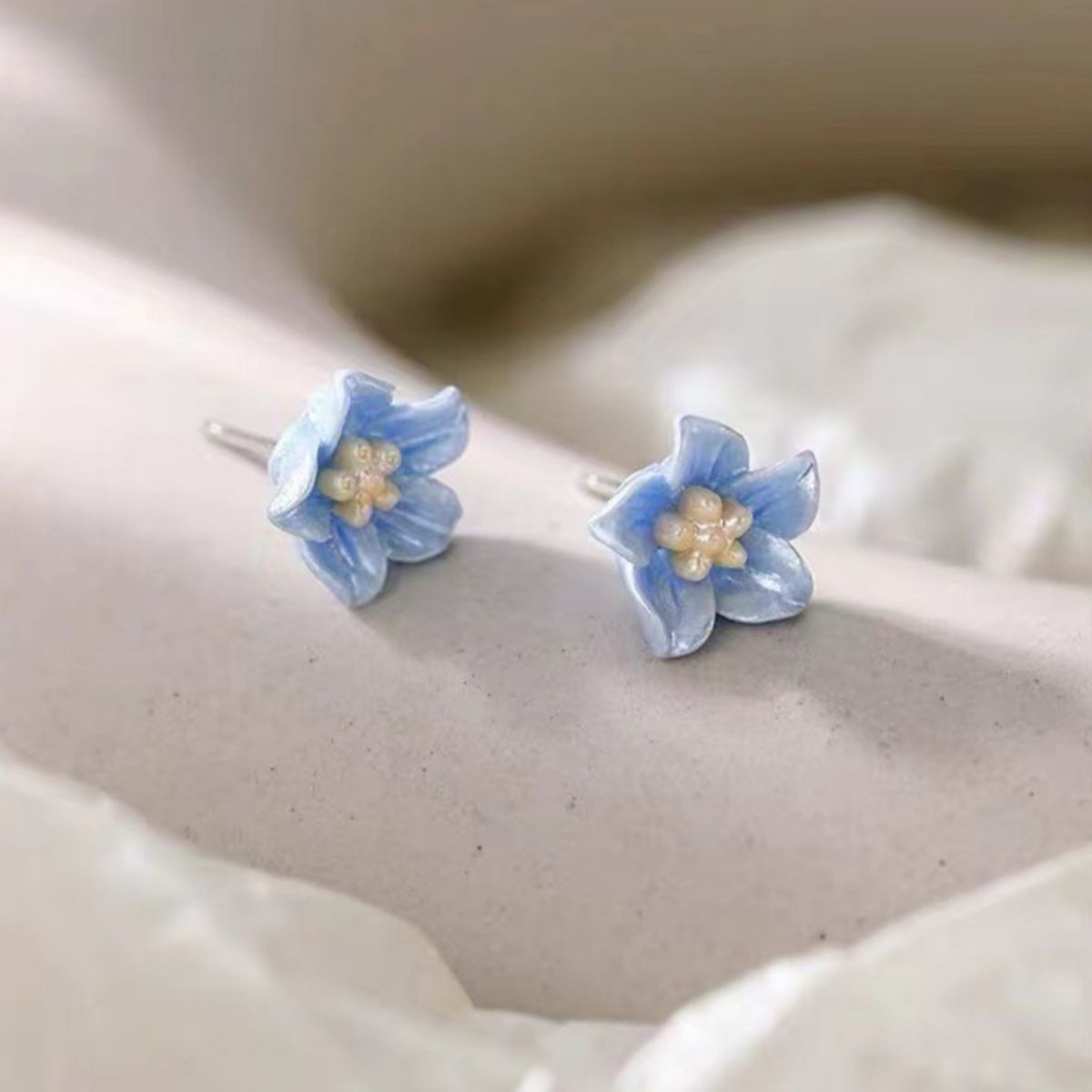 Small floral stud earrings with delicate resin petals