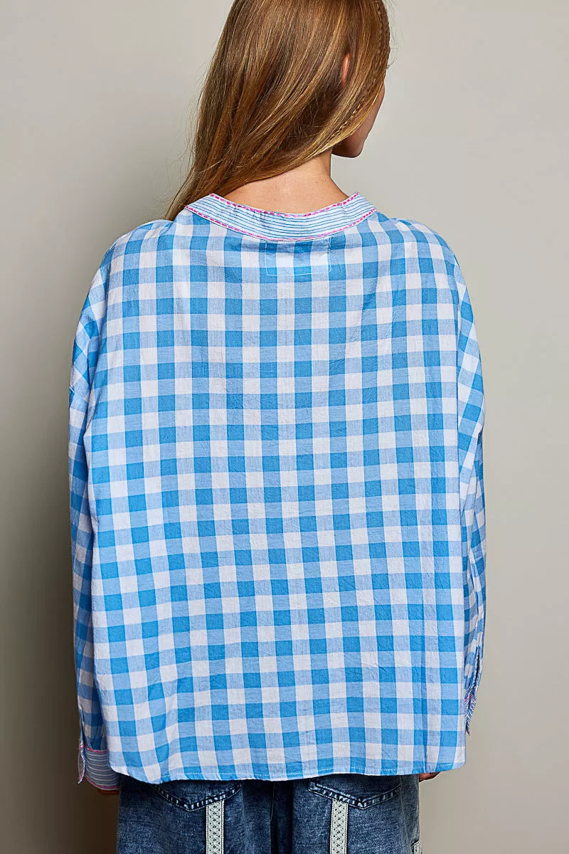 Blue and white gingham cotton blouse with buttoned neckline, lace detail, embroidered palm tree pocket, and relaxed fit.