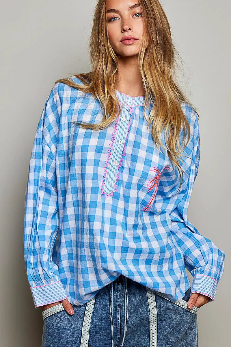 Blue and white gingham cotton blouse with buttoned neckline, lace detail, embroidered palm tree pocket, and relaxed fit.