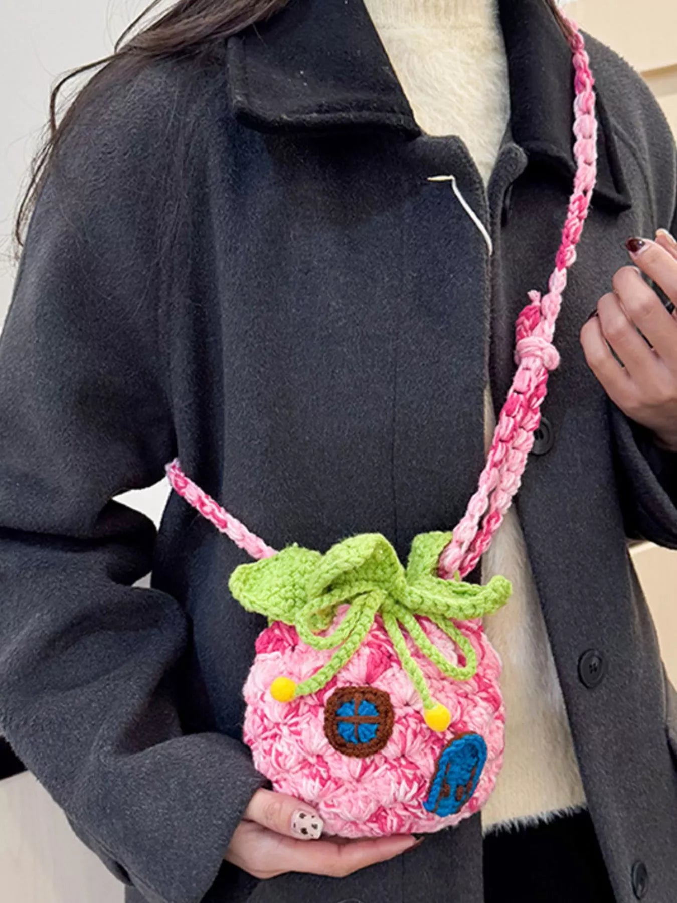 Pineapple-shaped knitted mini crossbody bag worn over a fuzzy sweater