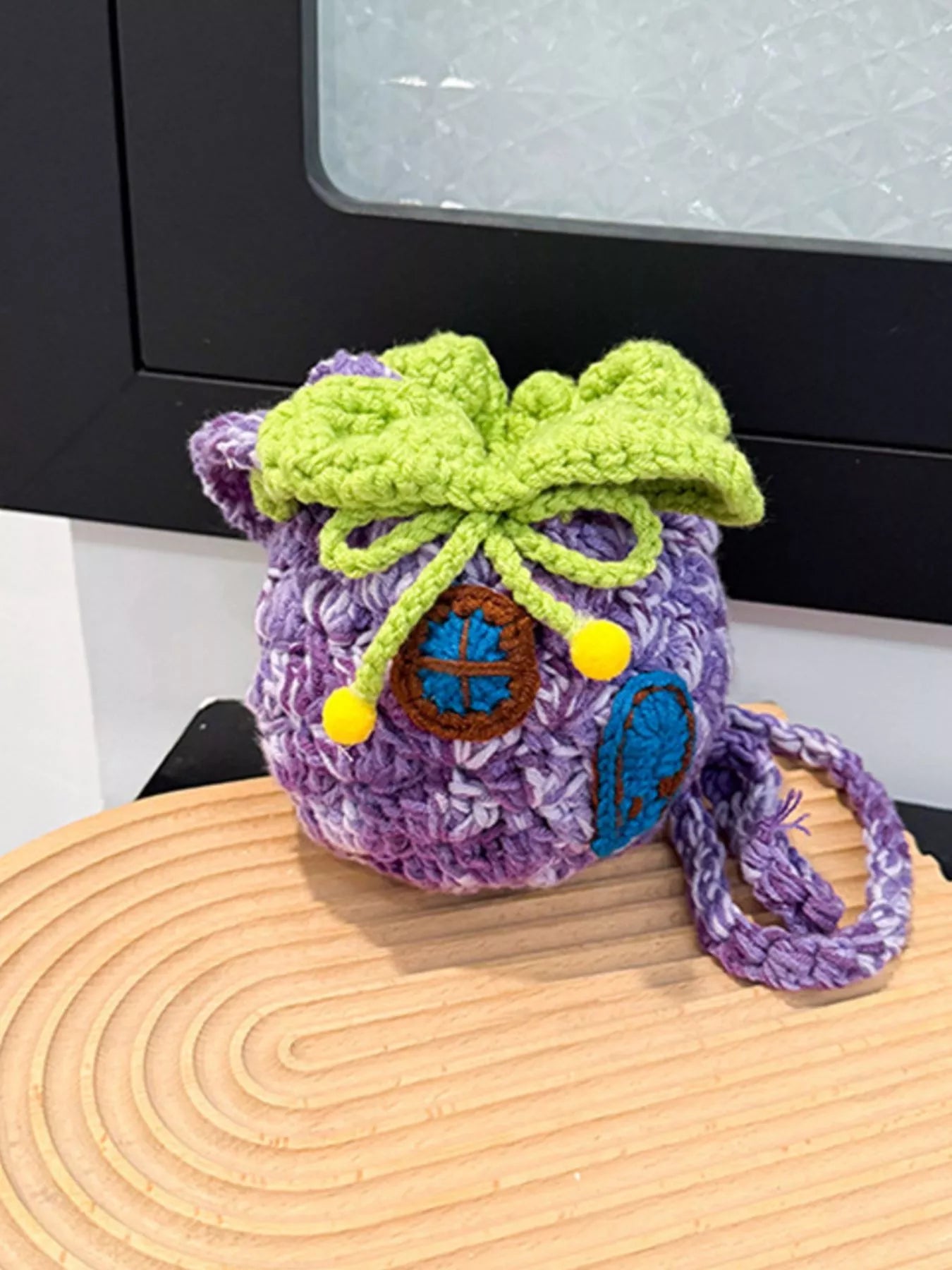 Pineapple-shaped knitted mini crossbody bag worn over a fuzzy sweater