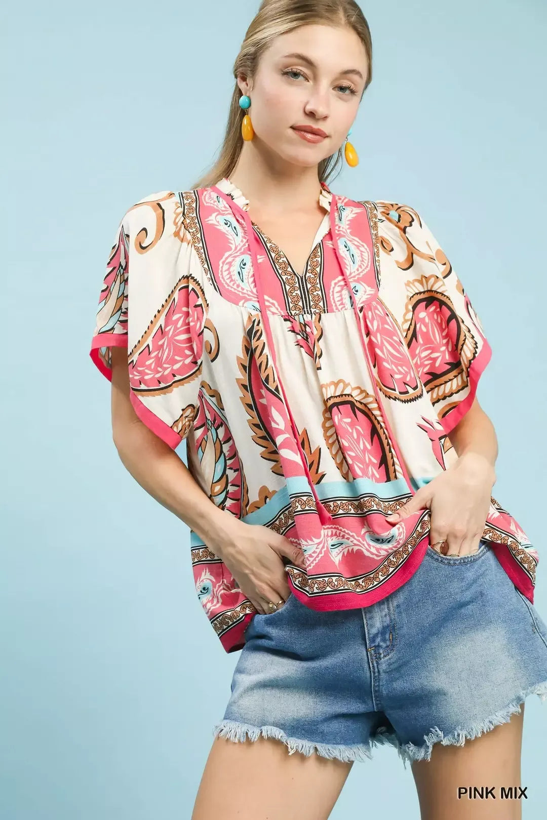 Pink mix paisley flutter sleeve top with tassel tie detail styled with denim shorts.