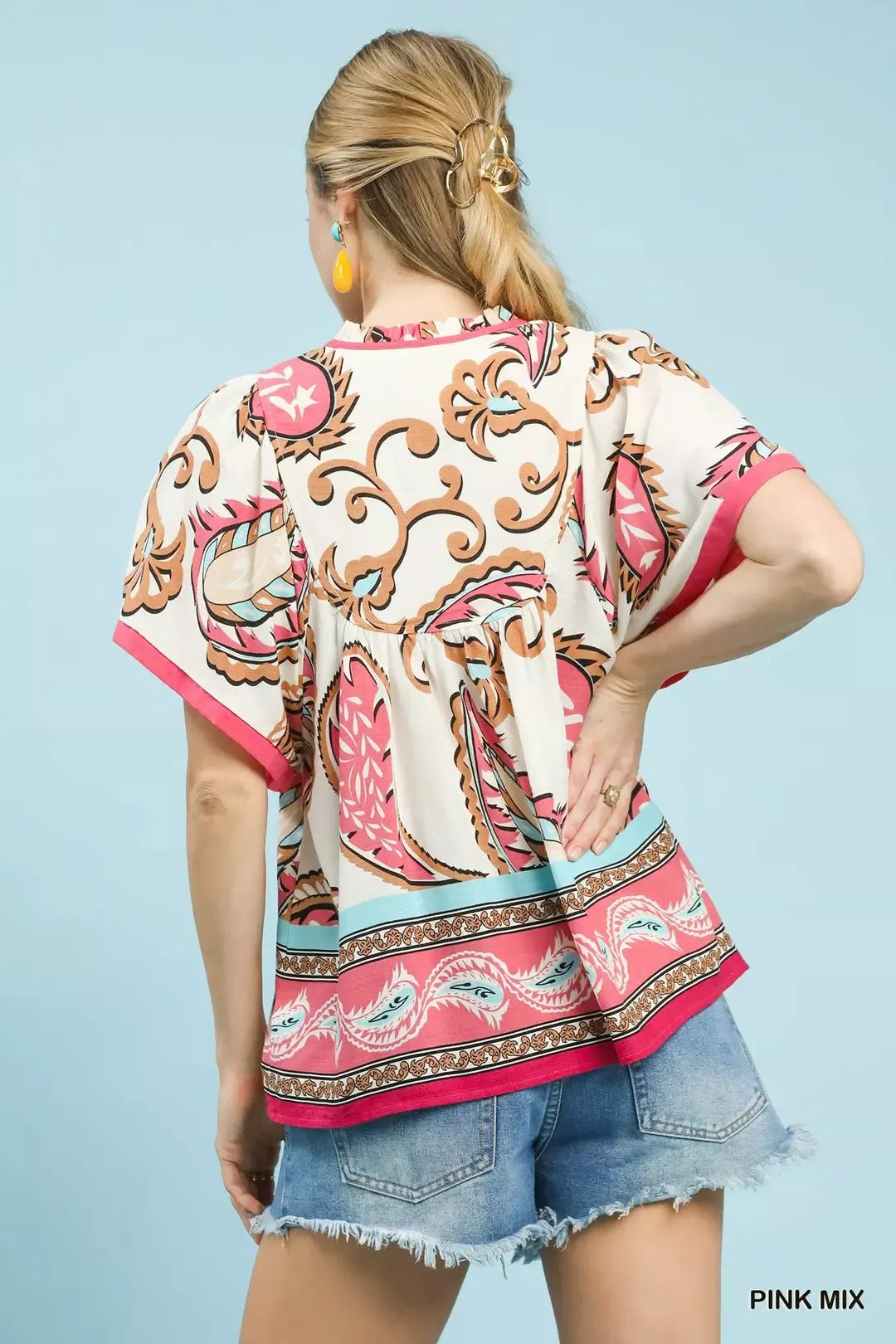 Pink mix paisley flutter sleeve top with tassel tie detail styled with denim shorts.