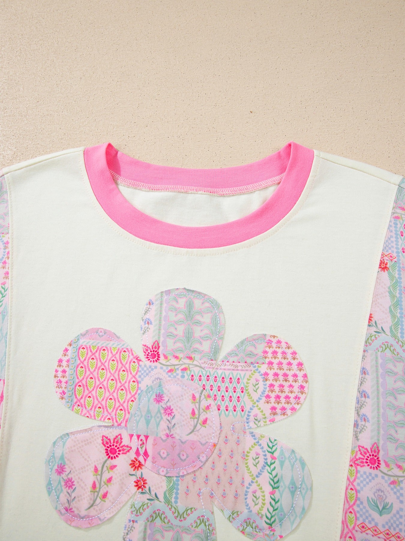 Woman wearing a pink patchwork floral short sleeve tee with bright contrast trim