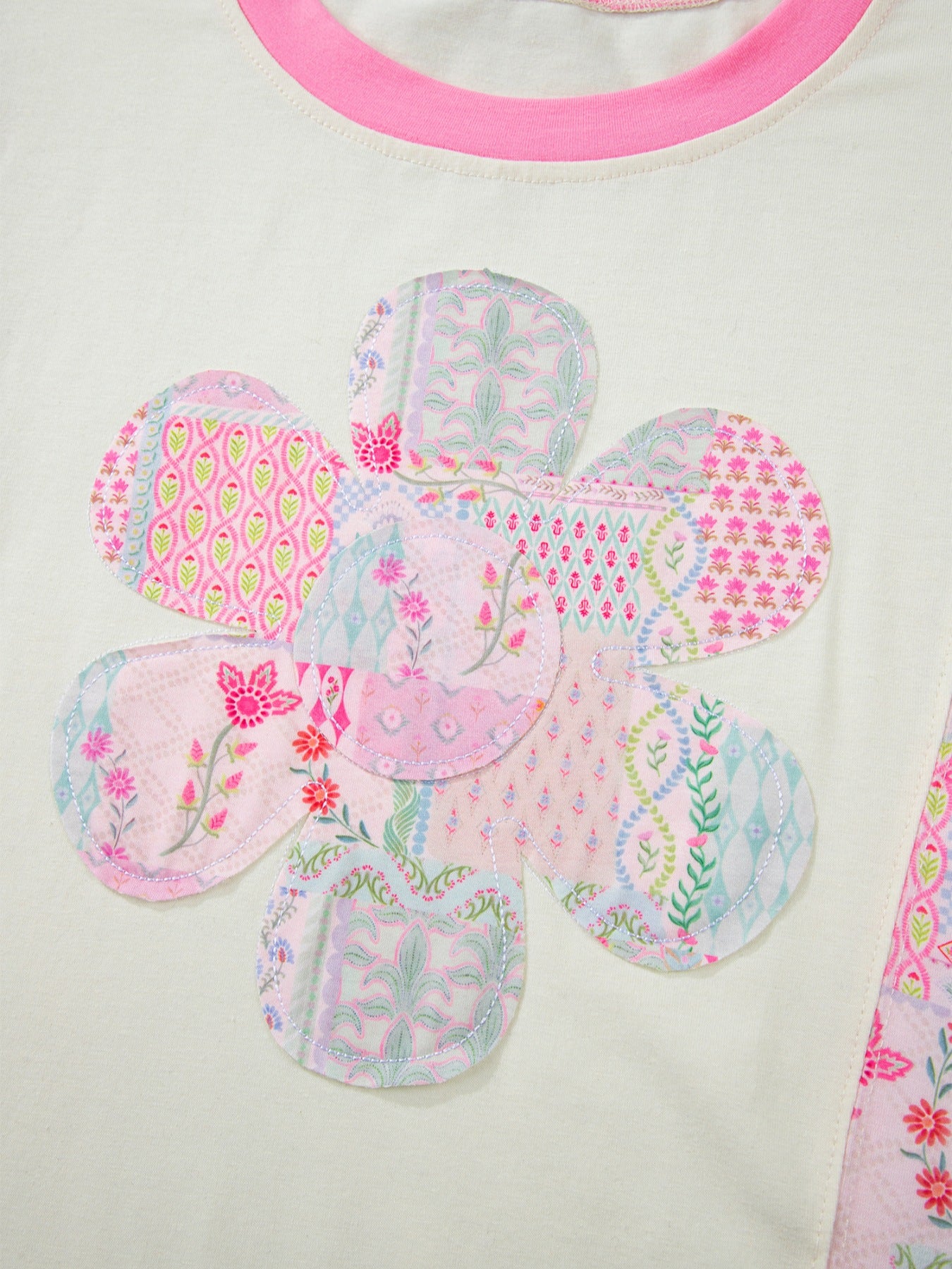 Woman wearing a pink patchwork floral short sleeve tee with bright contrast trim