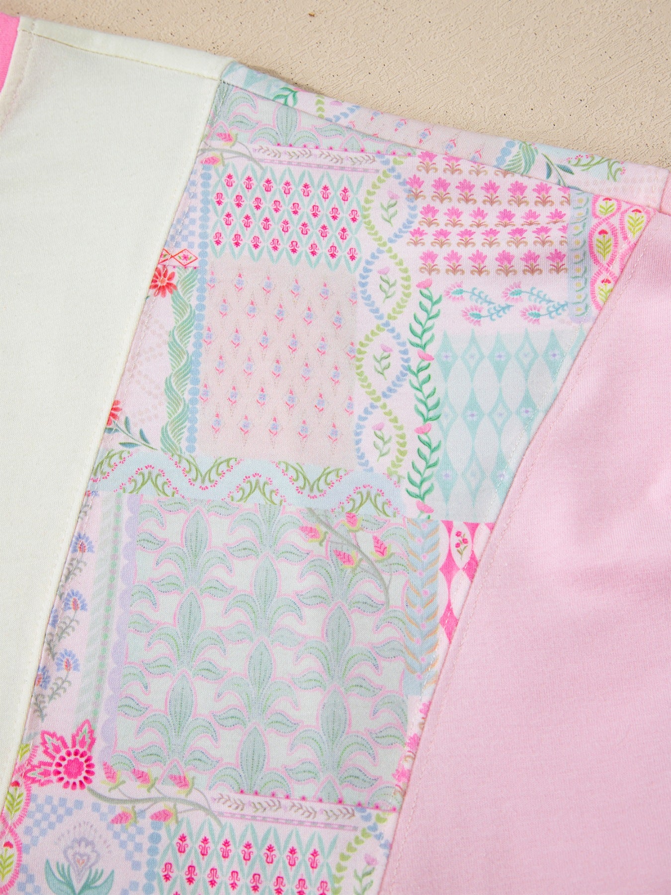 Woman wearing a pink patchwork floral short sleeve tee with bright contrast trim