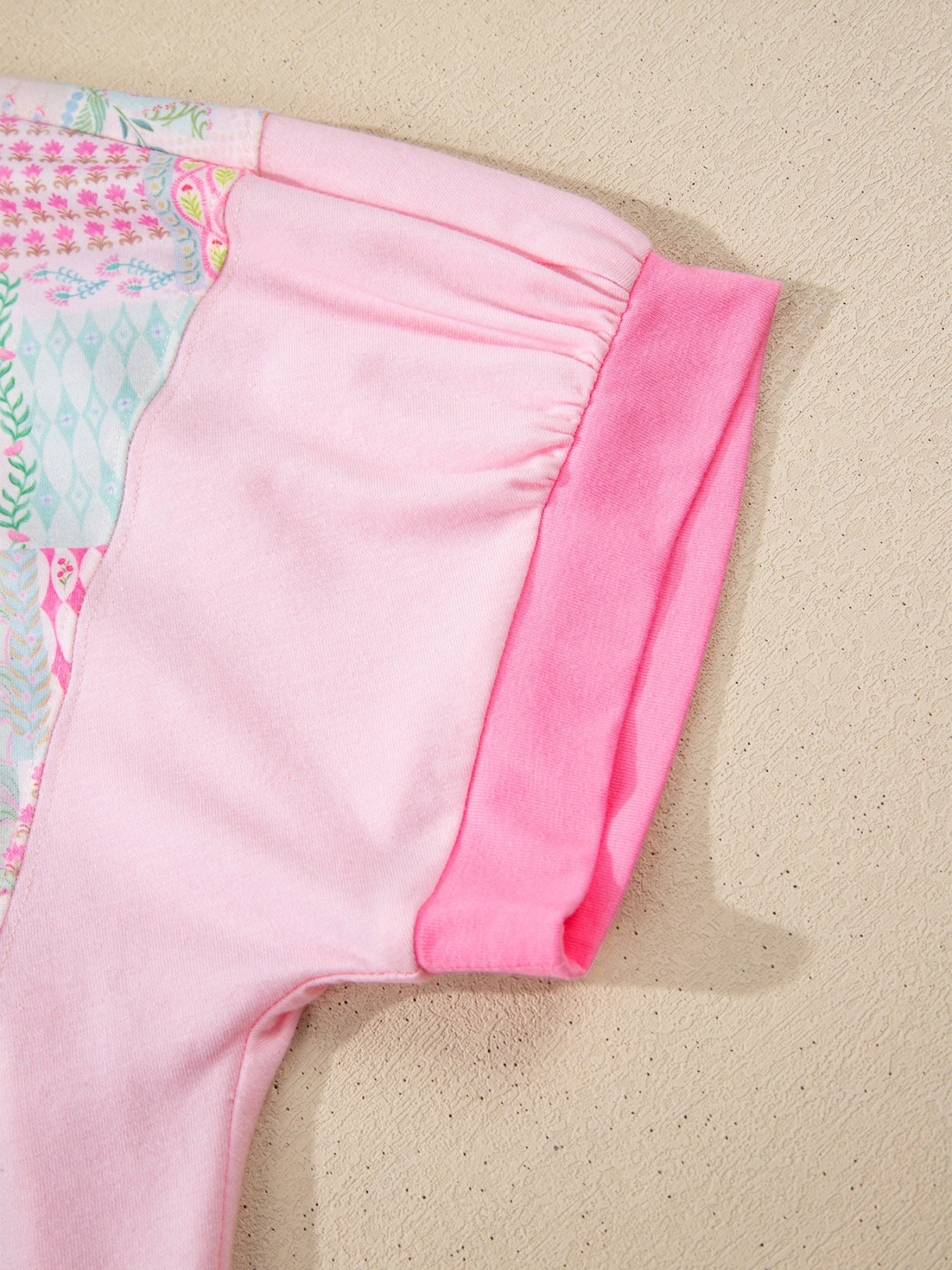 Woman wearing a pink patchwork floral short sleeve tee with bright contrast trim