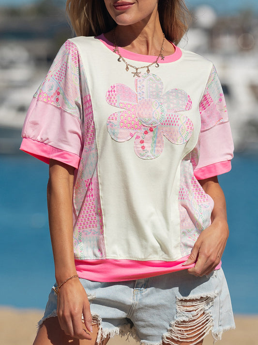 Woman wearing a pink patchwork floral short sleeve tee with bright contrast trim