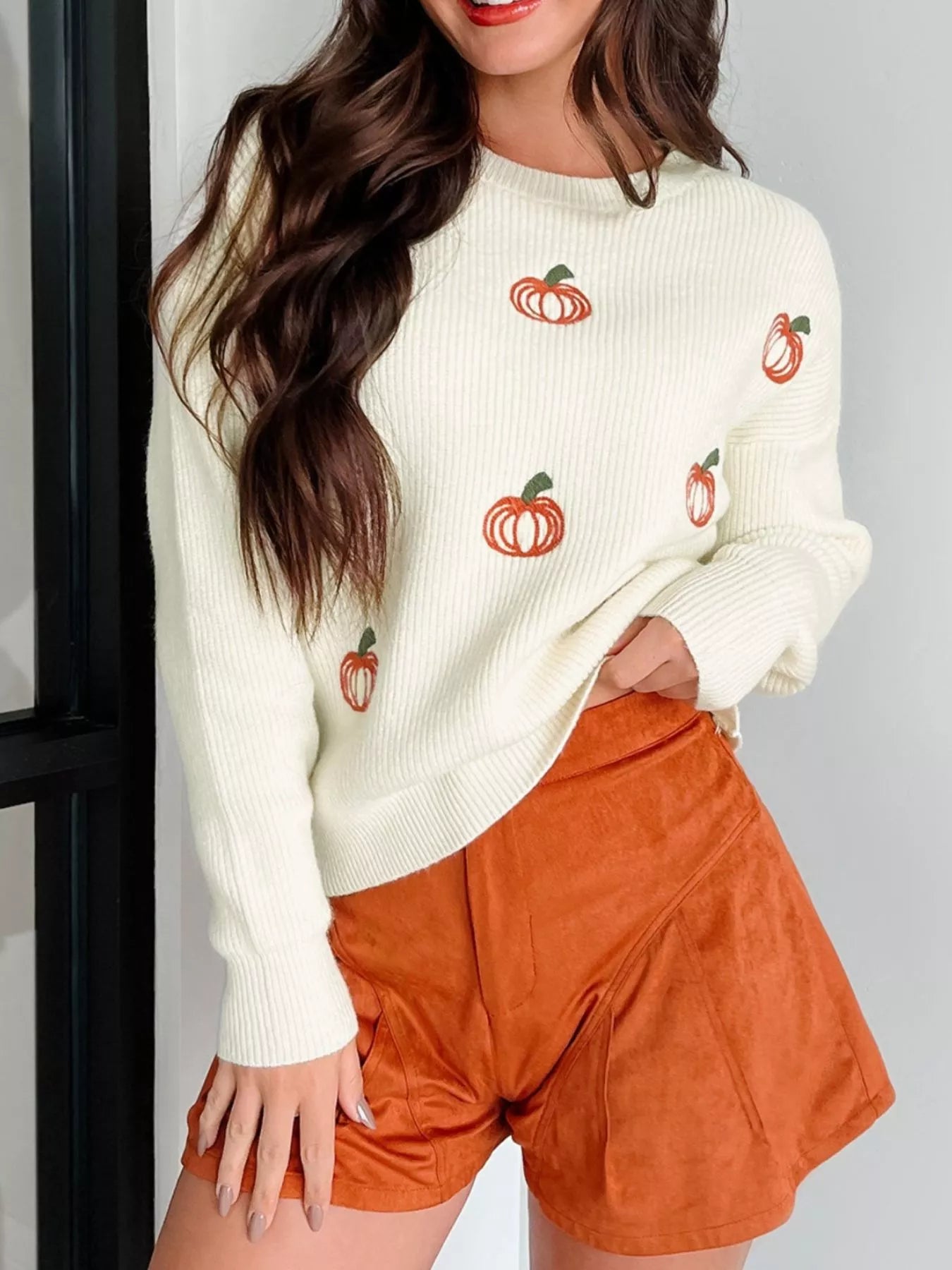 Cream knit sweater with embroidered pumpkins, round neck, and long sleeves – cozy fall style.