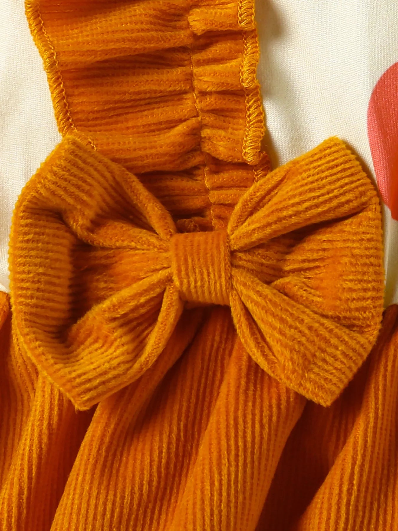 Baby girl pumpkin-print long-sleeve ruffle dress with bow headband and mustard corduroy skirt, styled for fall.