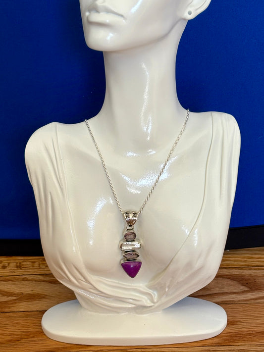 Mannequin bust wearing a necklace with a purple heart pendant against a blue background
