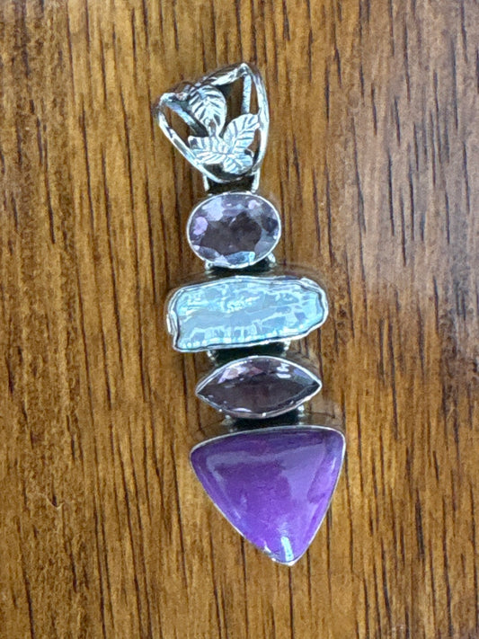 Multicolored gemstone pendant on a wooden surface