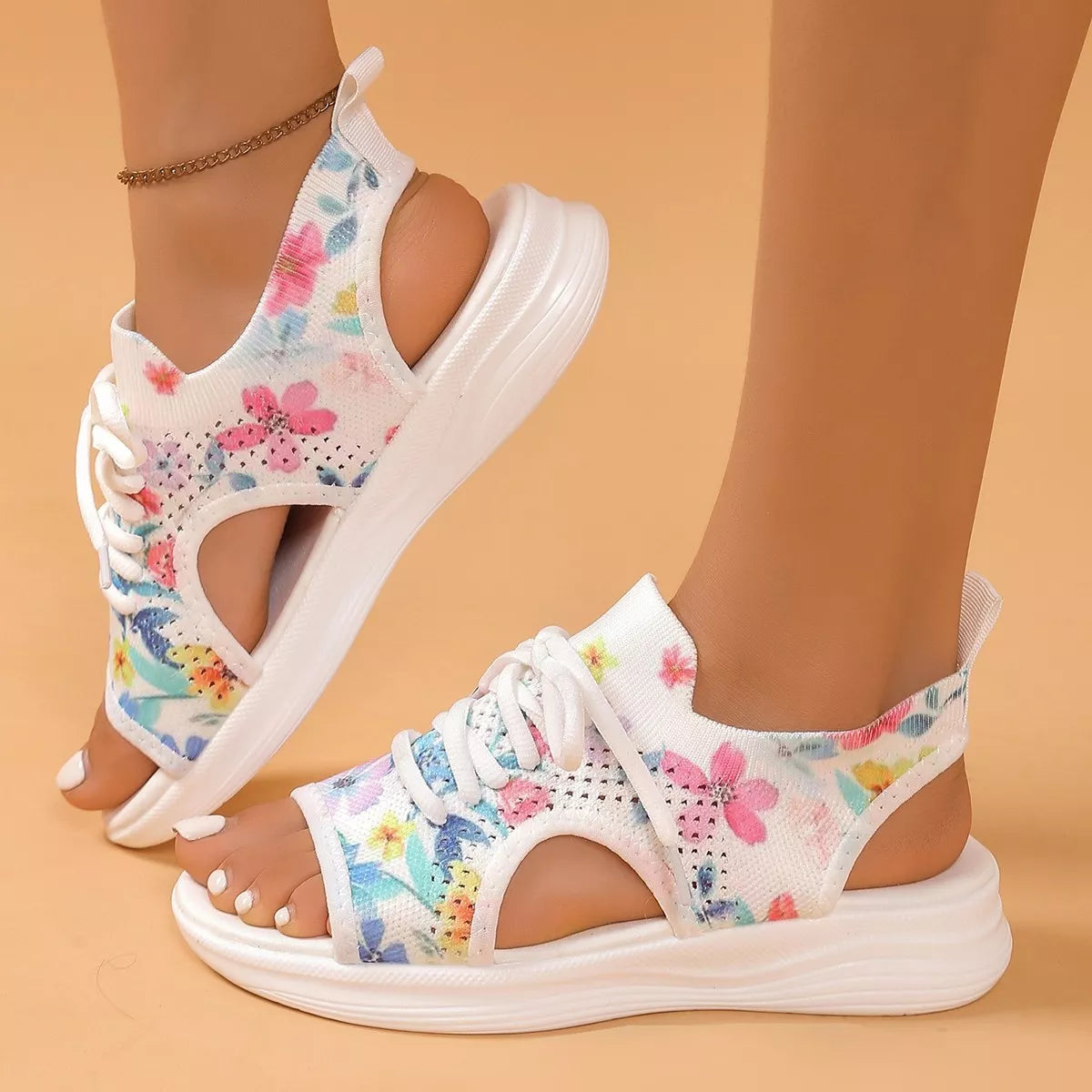 Colorful tie-dye mesh flat sandals with white laces, cutout sides, open toe design, and white rubber sole.