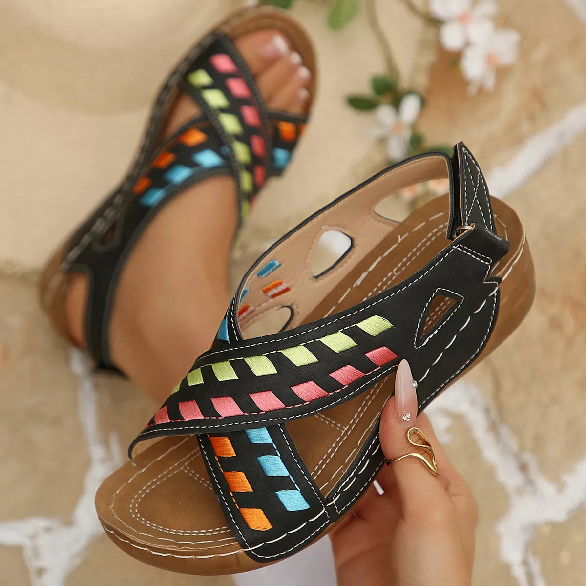 Black boho mid heel sandals with colorful woven-style accents, cutout details, contrast stitching, and brown sole.