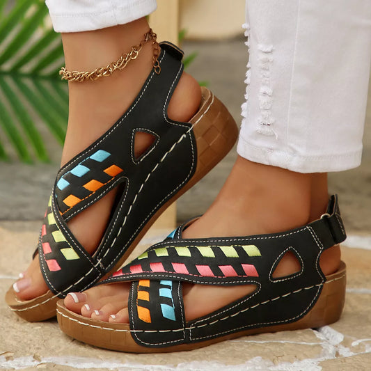 Black boho mid heel sandals with colorful woven-style accents, cutout details, contrast stitching, and brown sole.