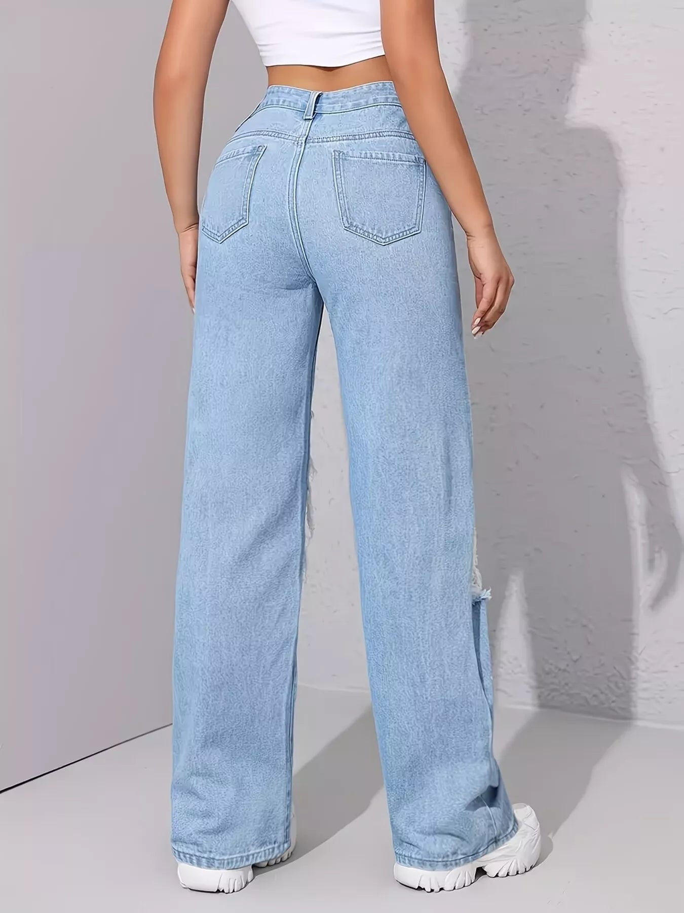 Light wash wide-leg jeans with distressed cutouts, raw hem details, seam accents, and black graphic print designs.