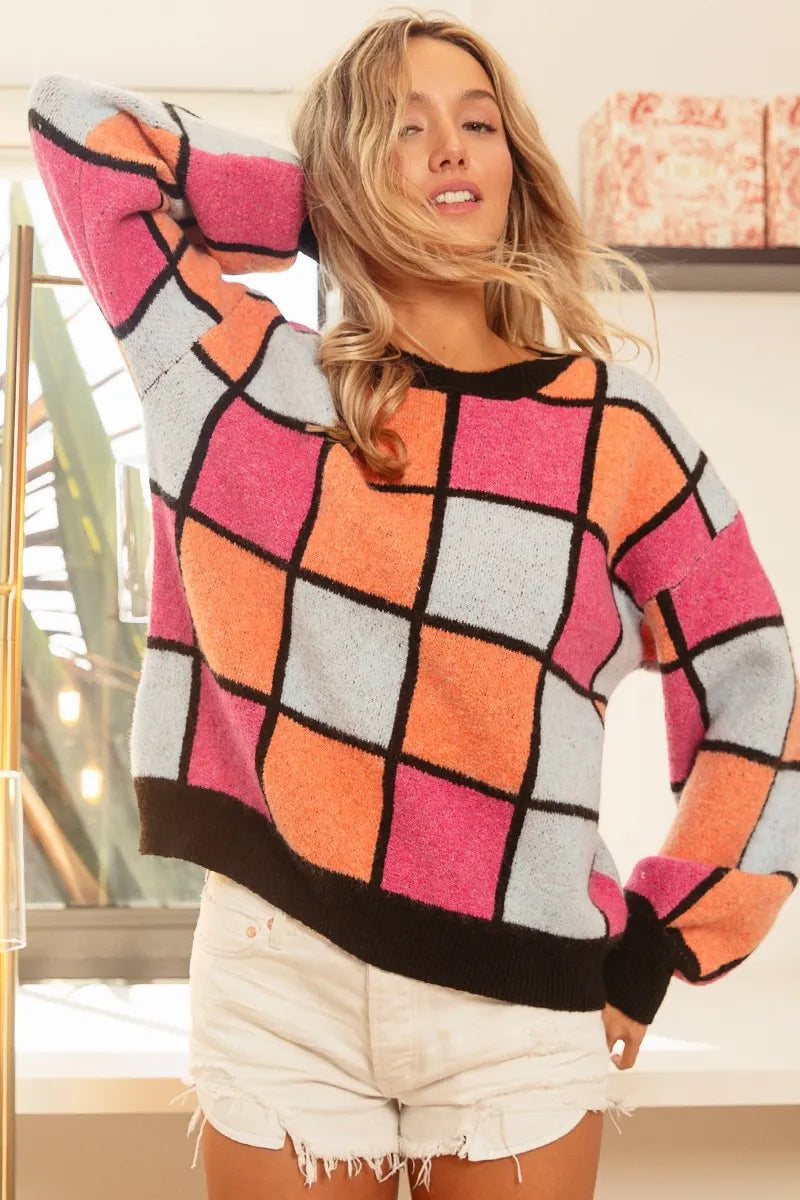 Colorful oversized sweater with pink, orange, and blue checker pattern outlined in black.