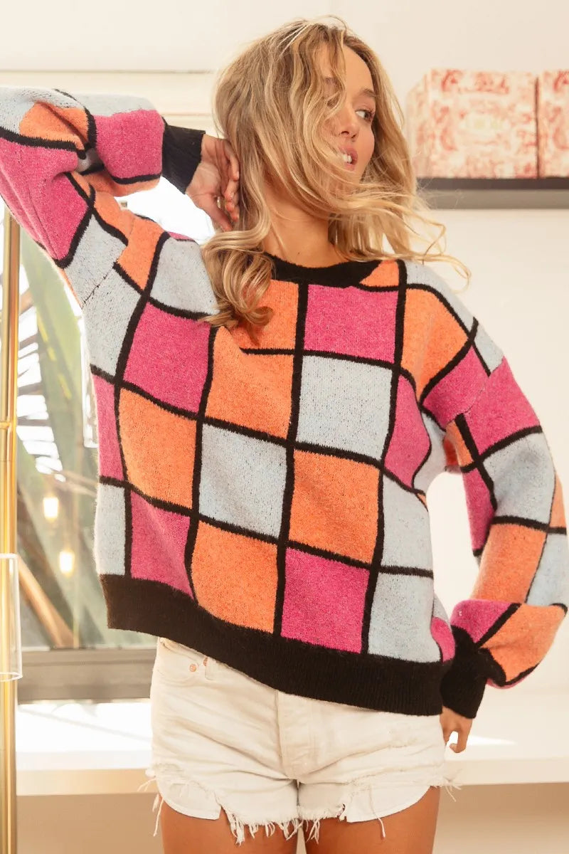 Colorful oversized sweater with pink, orange, and blue checker pattern outlined in black.