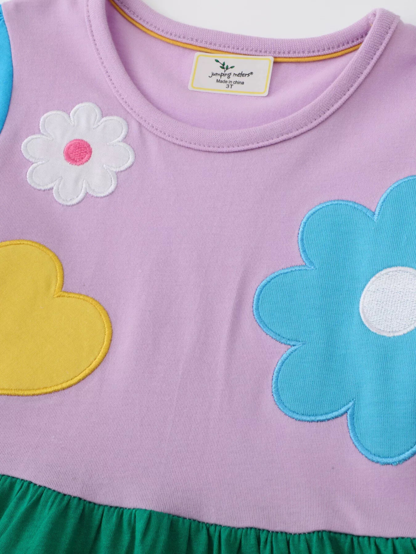 Colorful girls dress with oversized flower and heart appliqué and green skirt