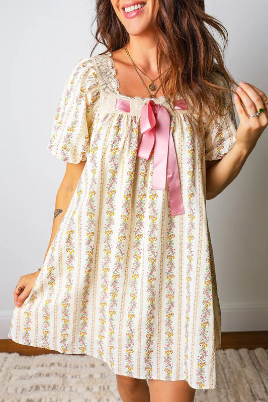 cream floral stripe babydoll dress with lace neckline, flutter sleeves, and pink satin bow detail