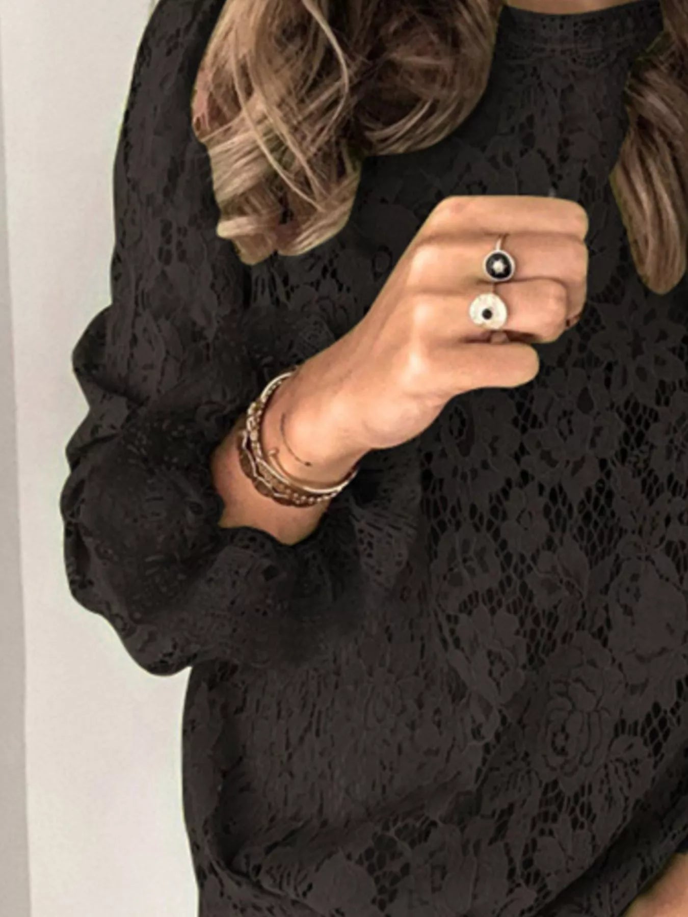 Black floral lace long sleeve blouse with round neck and sophisticated style.