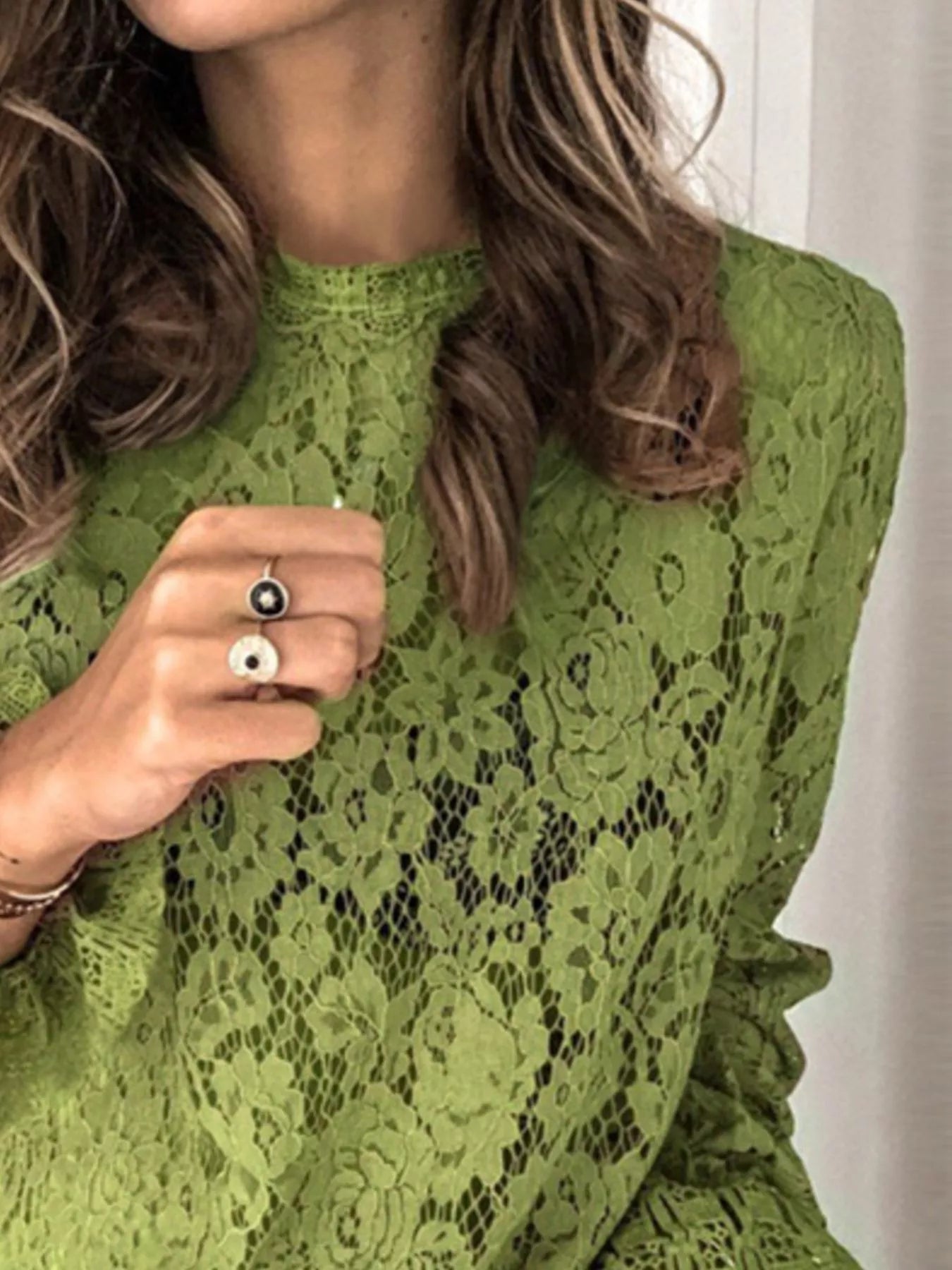 Green floral lace long sleeve blouse with round neck and delicate design.
