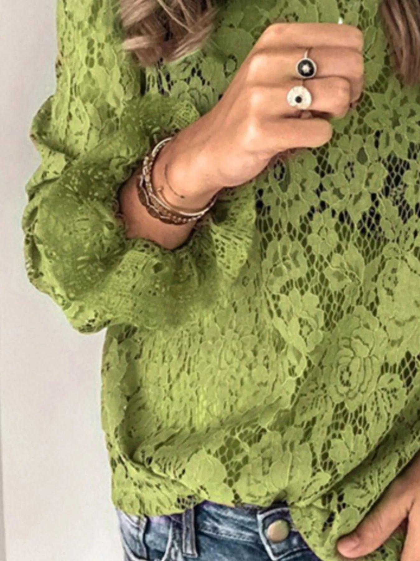 Green floral lace long sleeve blouse with round neck and delicate design.