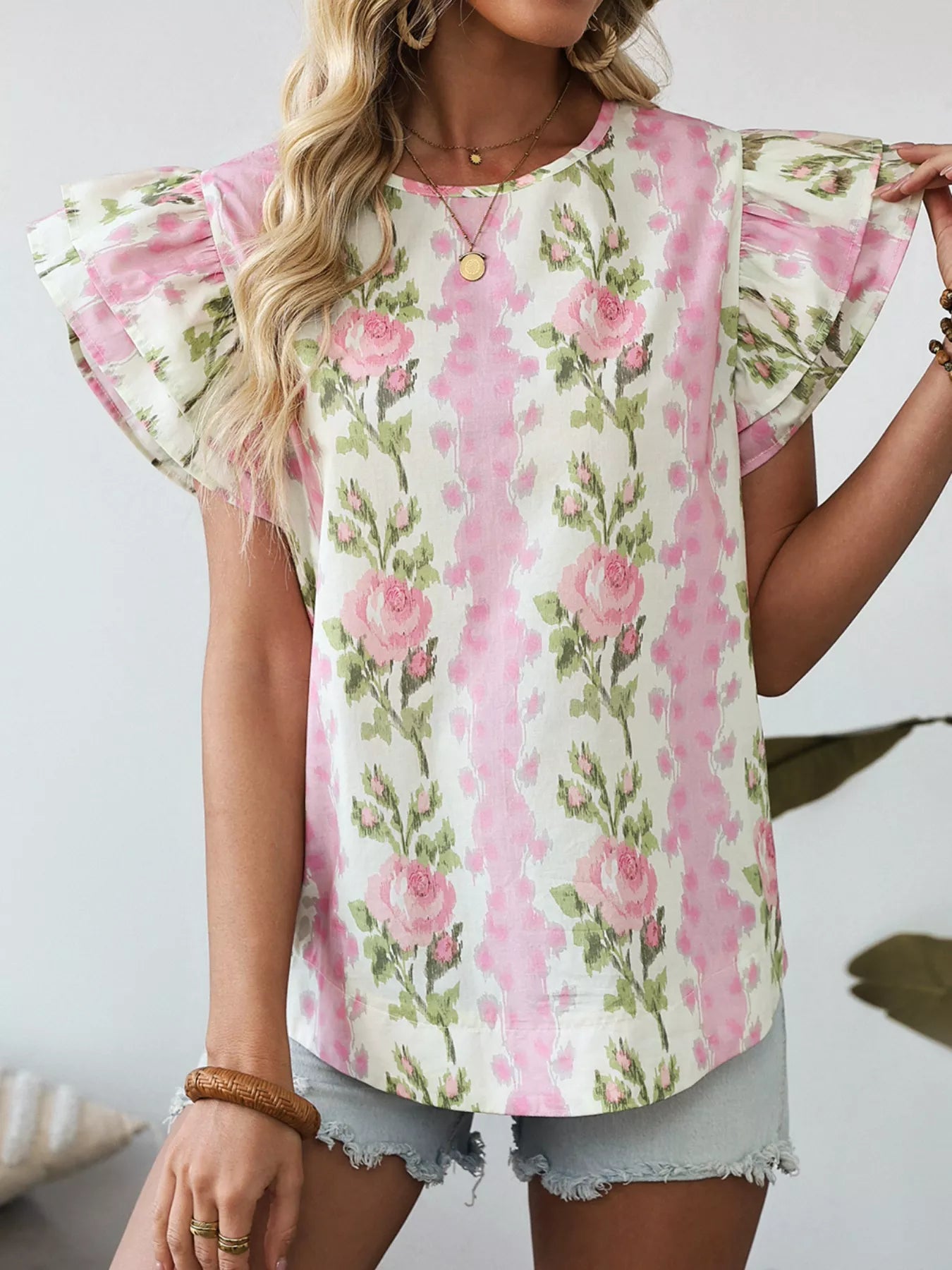 Pink floral cotton blouse with layered ruffle sleeves styled with light wash denim shorts and woven belt