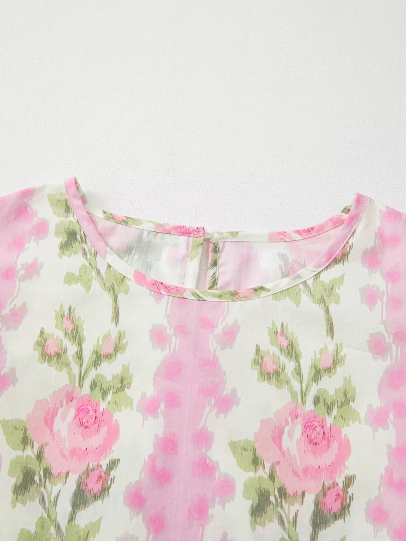 Pink floral cotton blouse with layered ruffle sleeves styled with light wash denim shorts and woven belt
