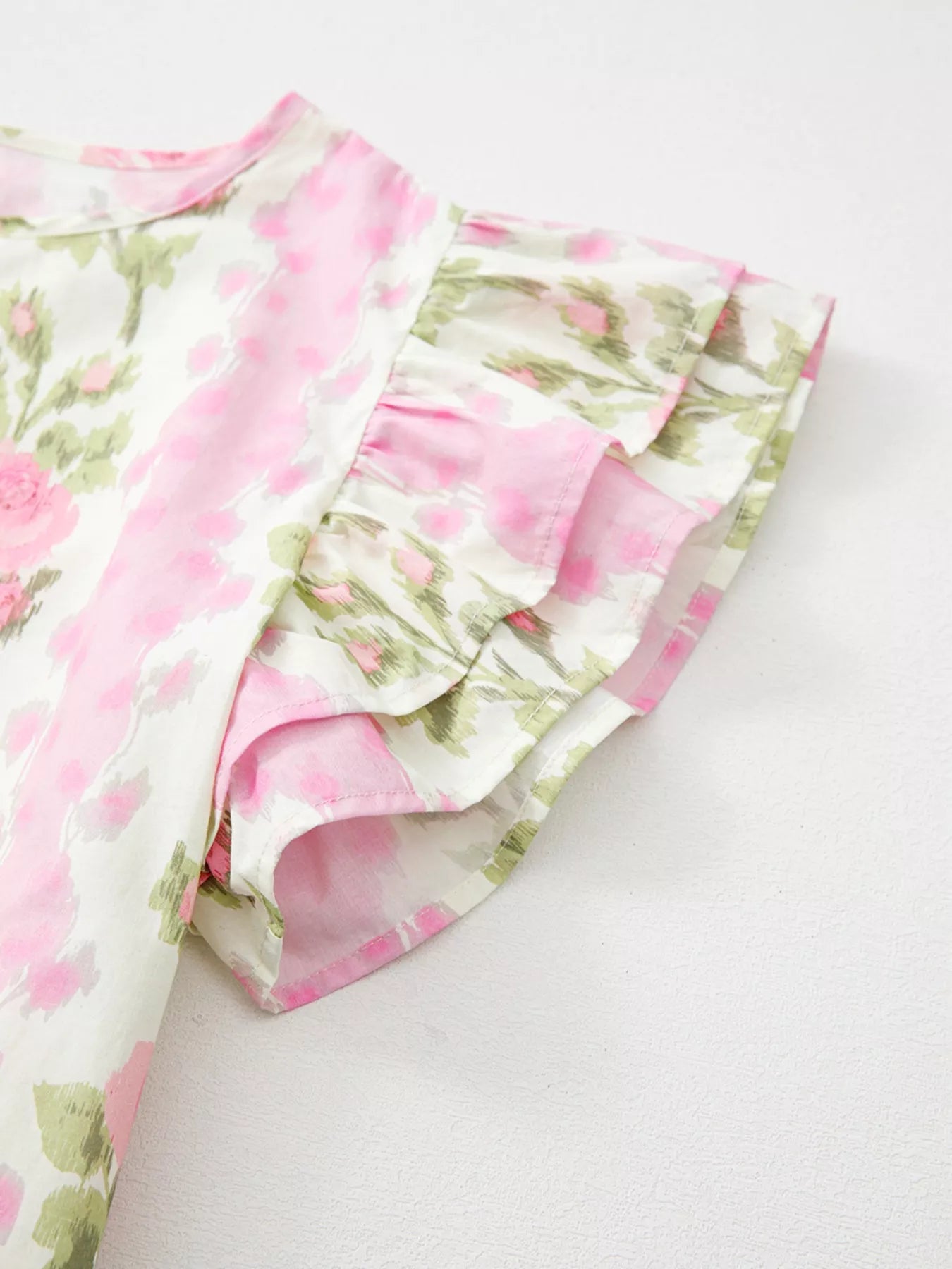 Pink floral cotton blouse with layered ruffle sleeves styled with light wash denim shorts and woven belt