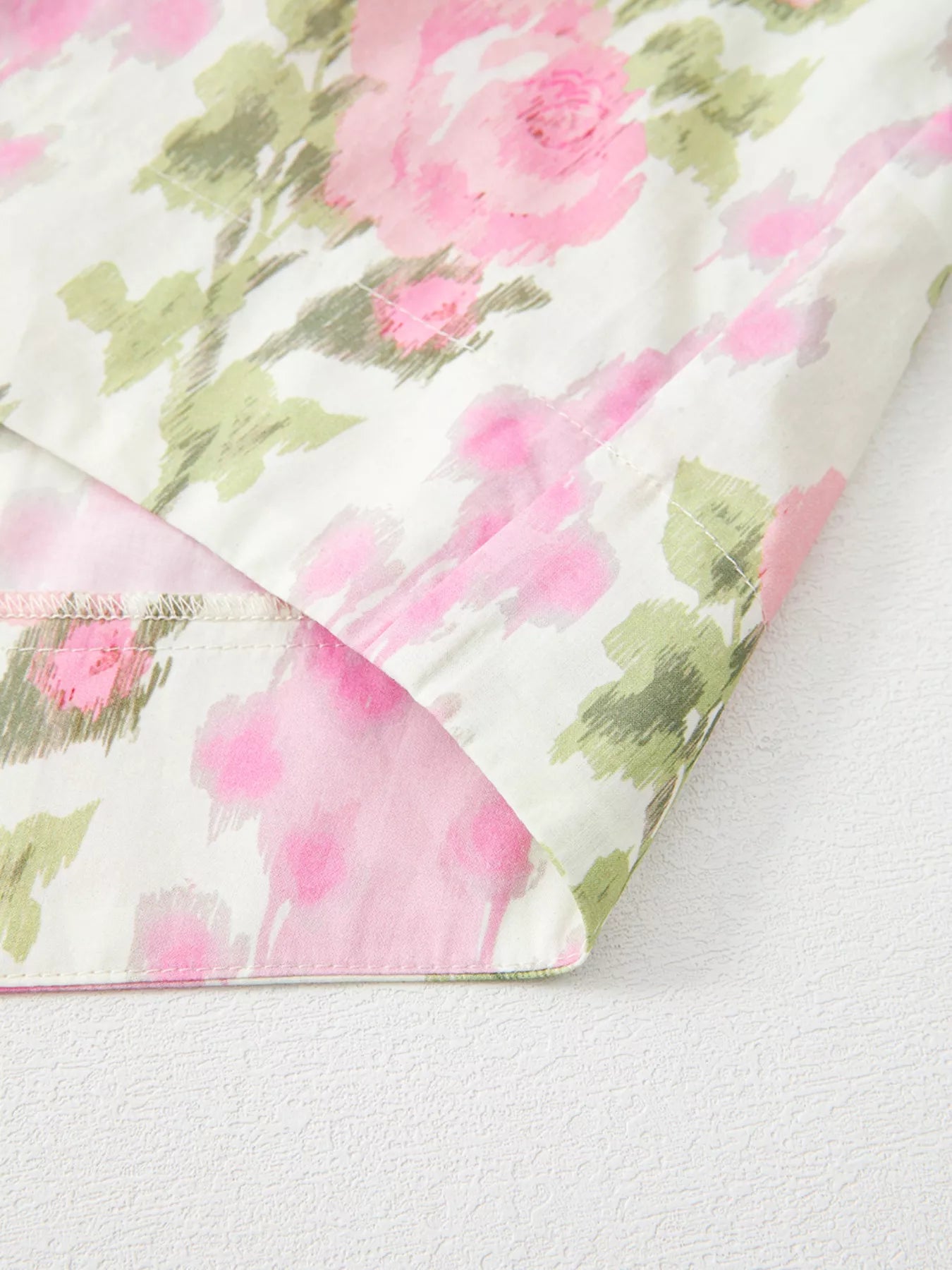 Pink floral cotton blouse with layered ruffle sleeves styled with light wash denim shorts and woven belt