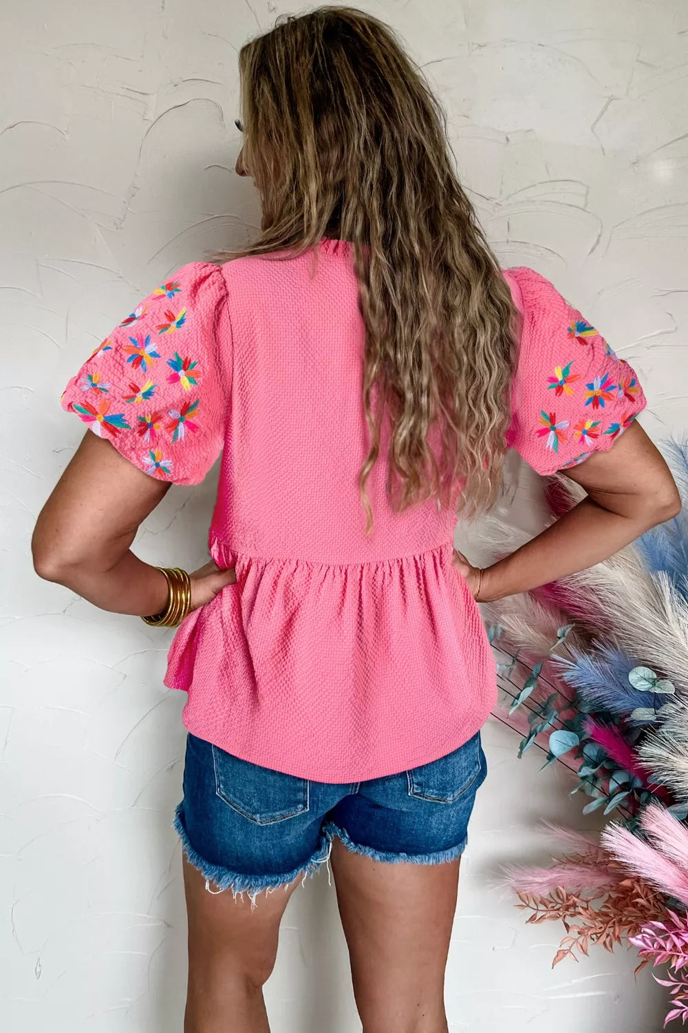 Pink textured peplum top with embroidered puff sleeves