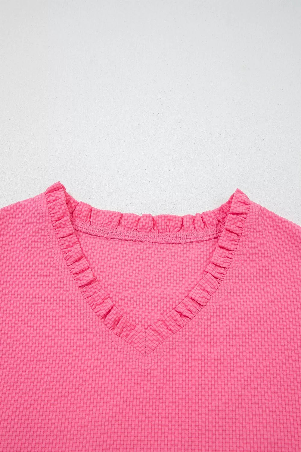 Pink textured peplum top with embroidered puff sleeves