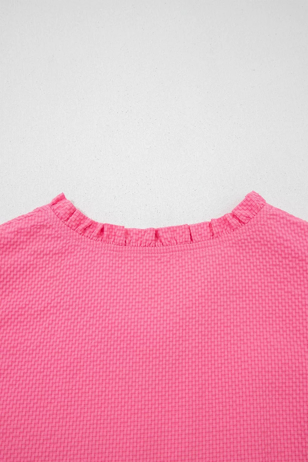 Pink textured peplum top with embroidered puff sleeves