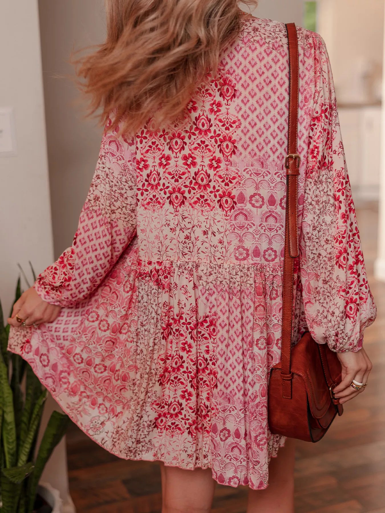 Rosé Reverie Mini Dress – flowy floral print boho dress with tassel tie neckline and ruffle details.