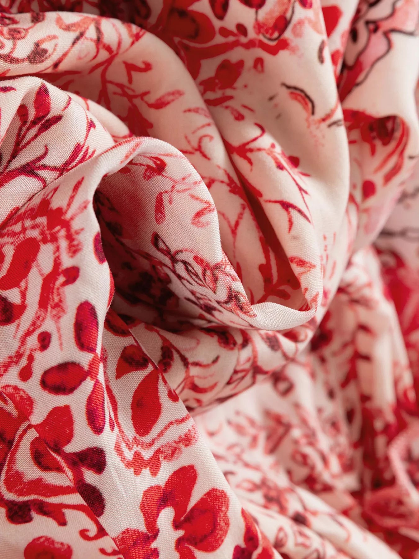 Rosé Reverie Mini Dress – flowy floral print boho dress with tassel tie neckline and ruffle details.
