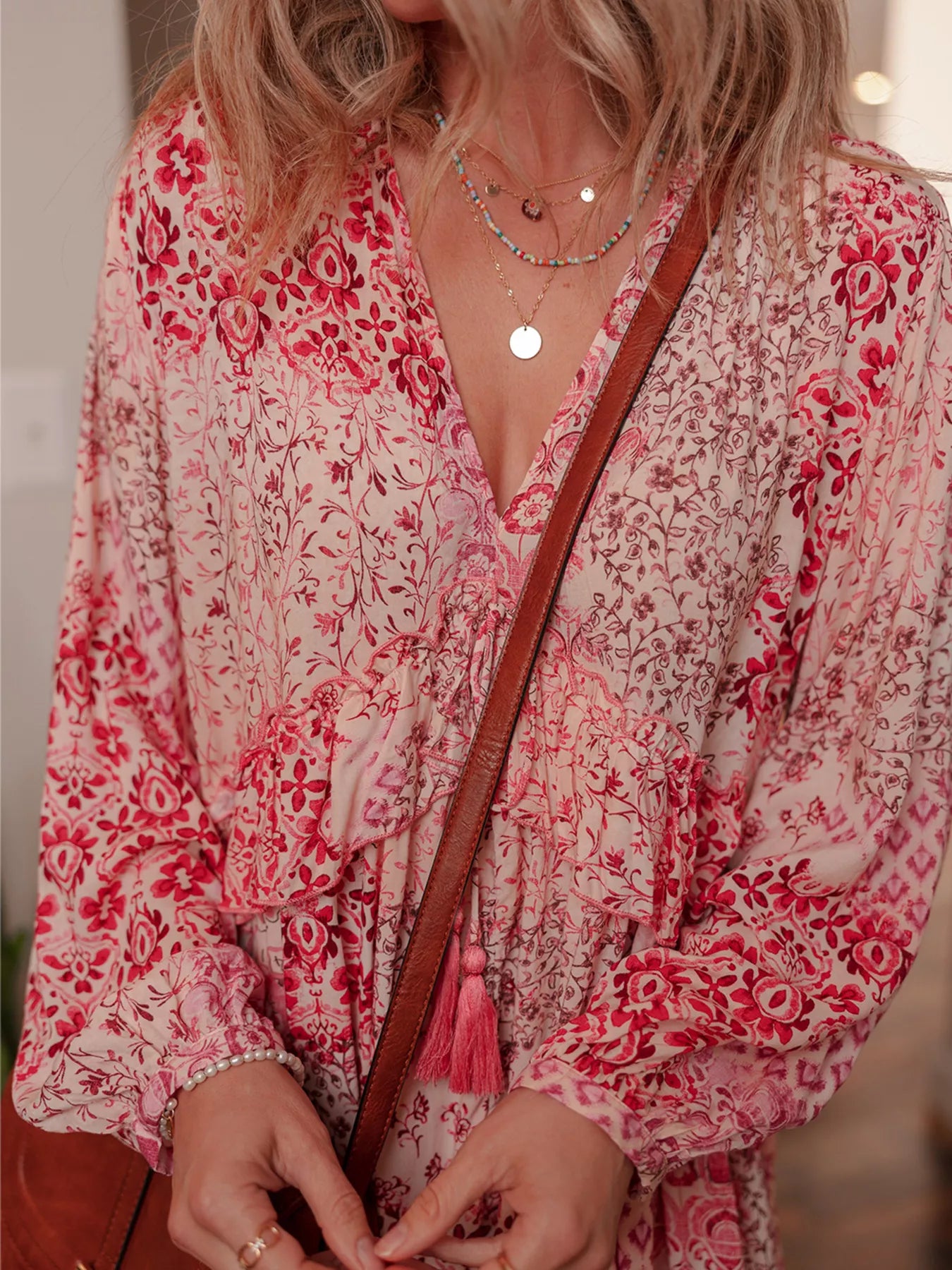 Rosé Reverie Mini Dress – flowy floral print boho dress with tassel tie neckline and ruffle details.