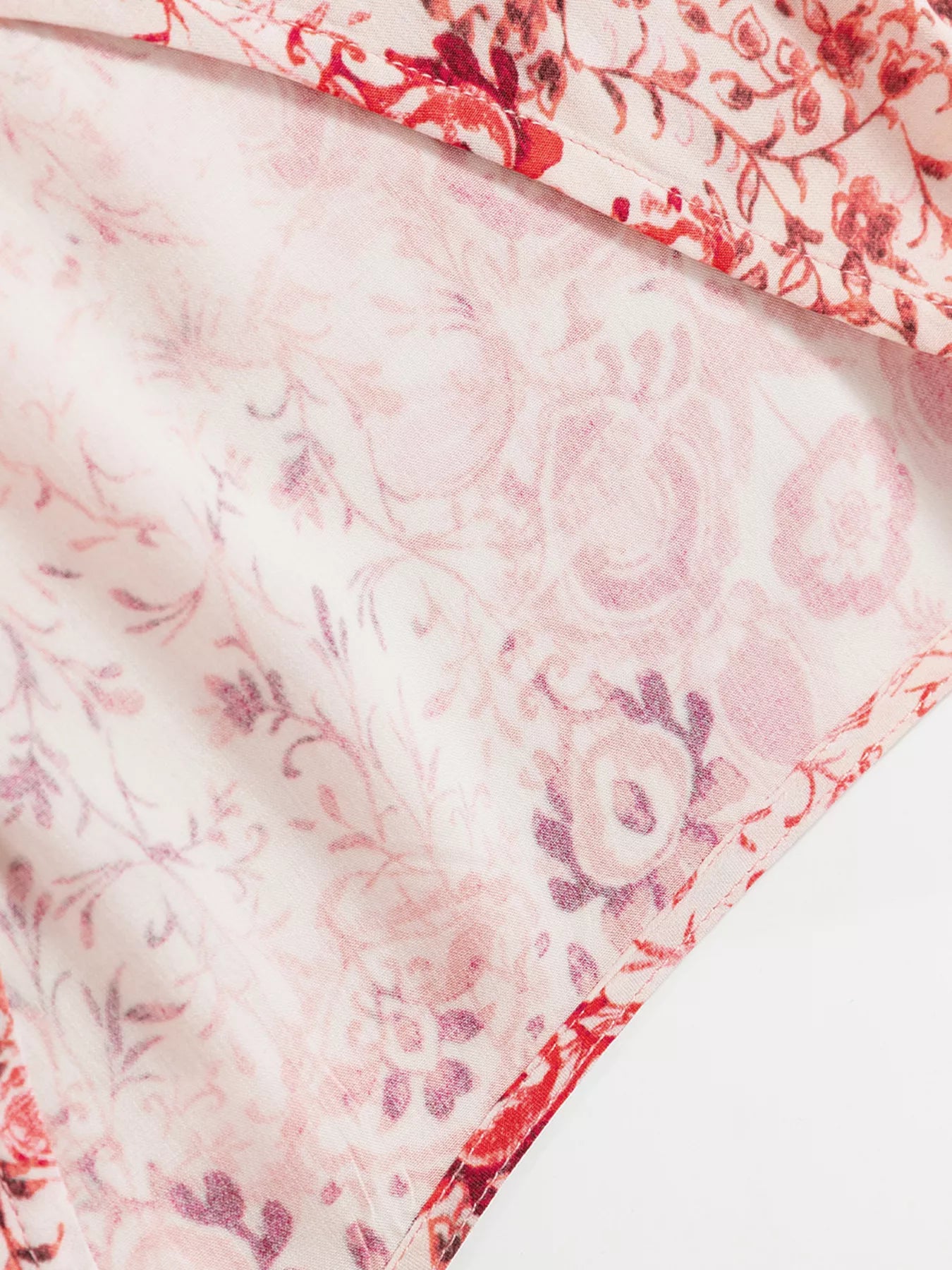Rosé Reverie Mini Dress – flowy floral print boho dress with tassel tie neckline and ruffle details.