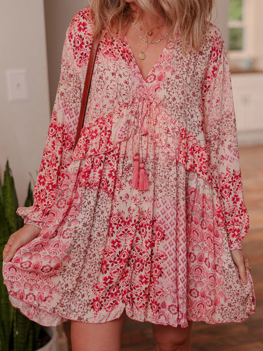 Rosé Reverie Mini Dress – flowy floral print boho dress with tassel tie neckline and ruffle details.