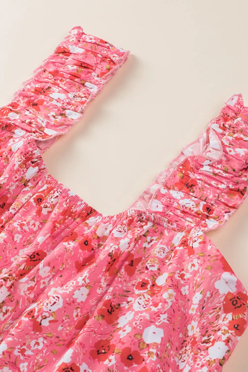 Pink tiered floral mini dress with ruffle detailing and sleeveless design