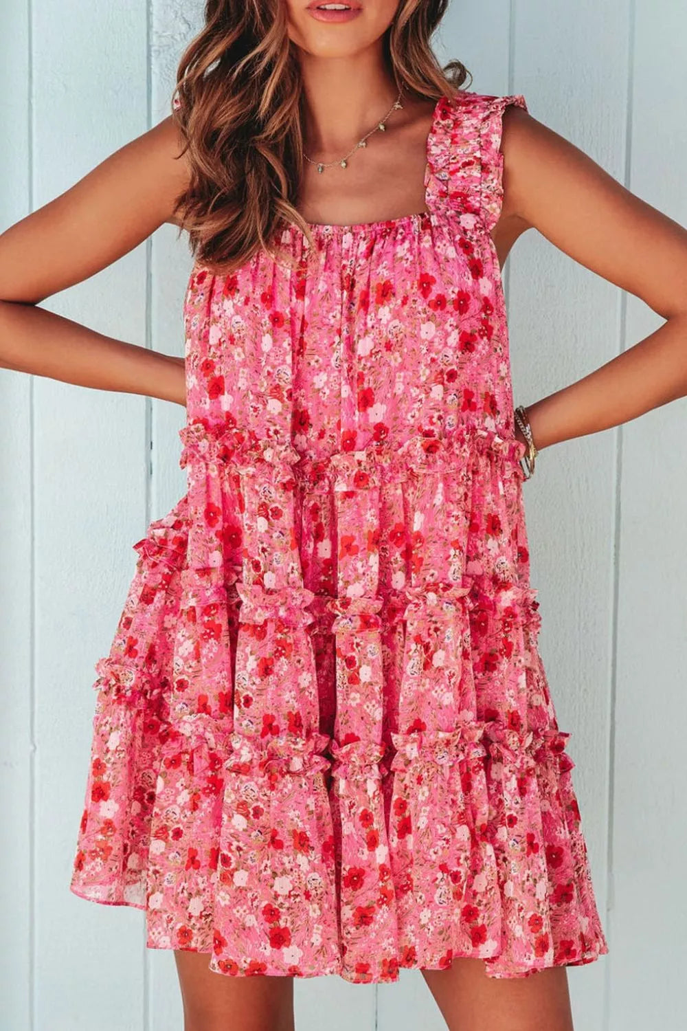 Pink tiered floral mini dress with ruffle detailing and sleeveless design