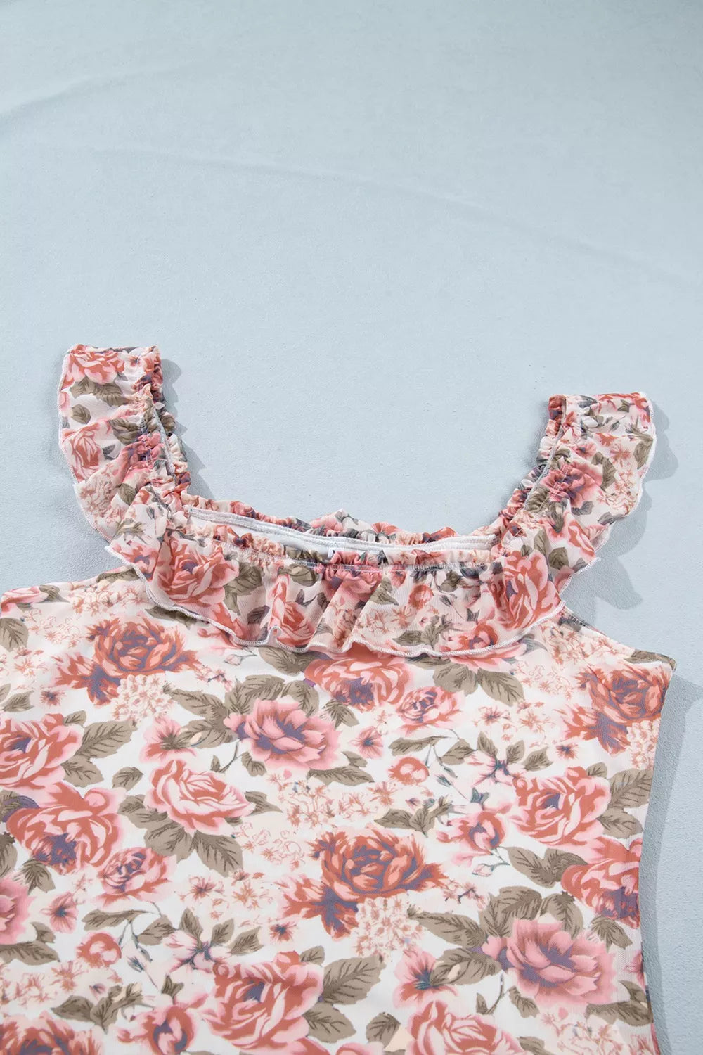 Floral ruffle sleeve top with a romantic rose print, square neckline, and slightly stretchy fit styled with jeans.