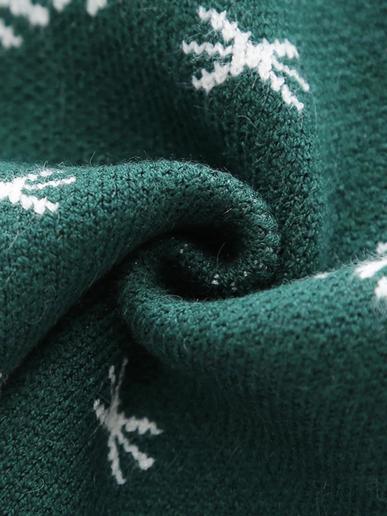 Kids’ green reindeer Christmas sweater with red trim and white snowflakes.