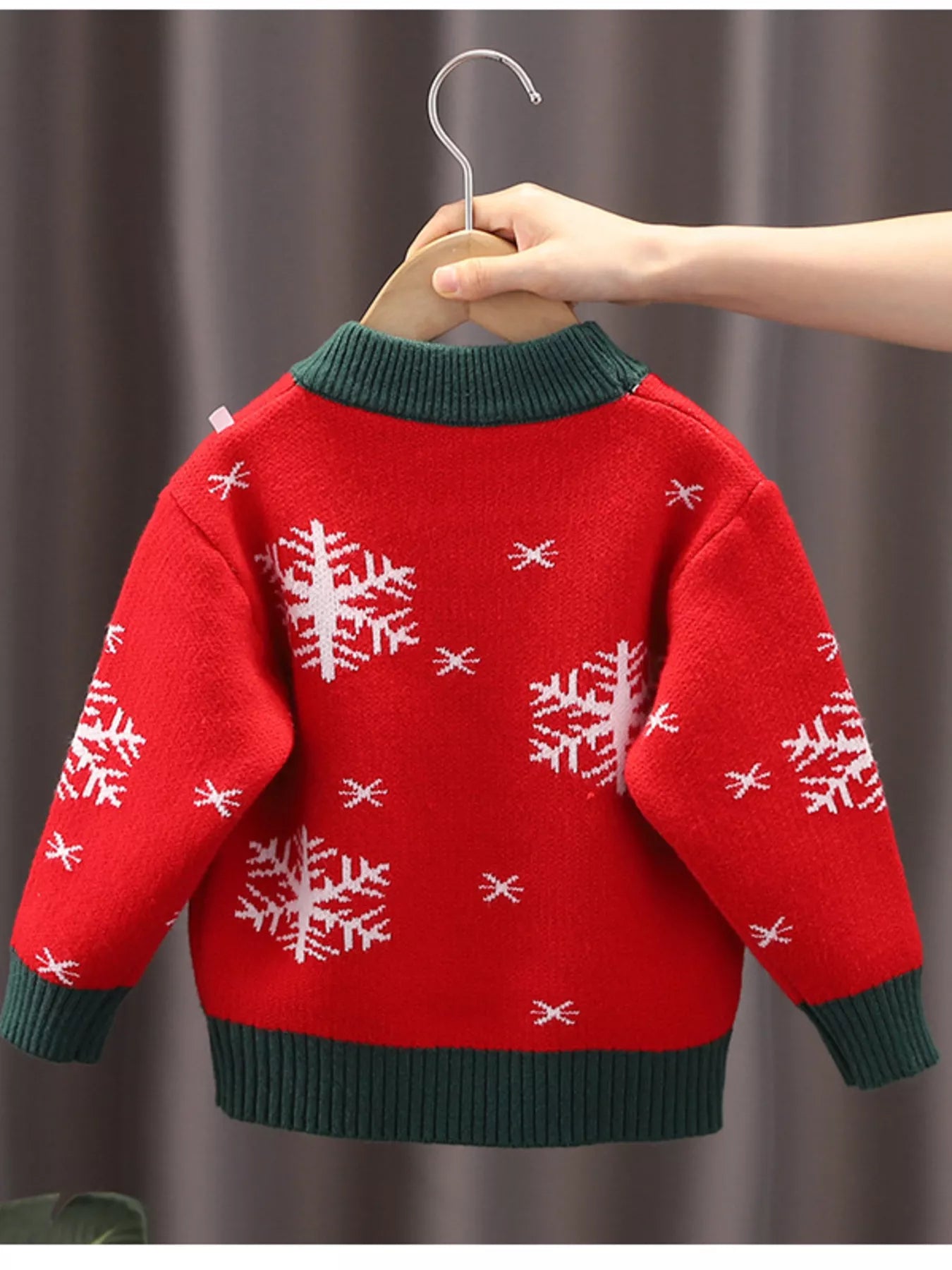 Kids’ red reindeer Christmas sweater with green trim and white snowflakes.