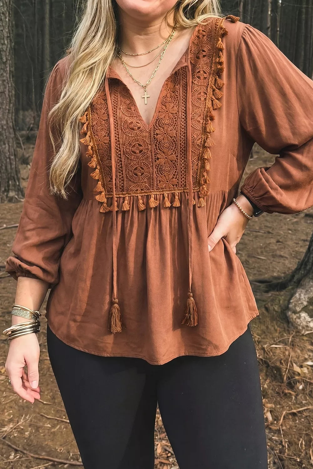 Rustic boho blouse with embroidered front detail, tassel trim, tied neckline, flowy long sleeves, and slightly stretchy fabric.