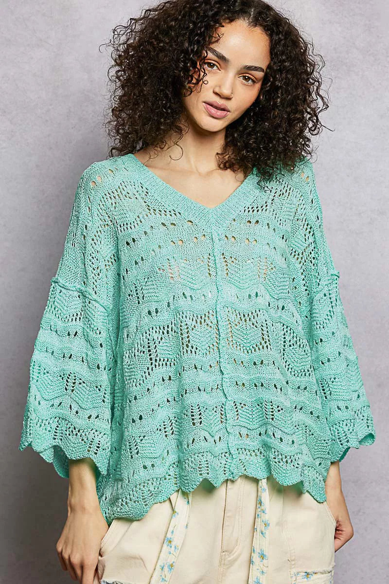 Oversized seafoam green openwork sweater top with V-neck, dropped shoulders, and 3/4 sleeves worn casually