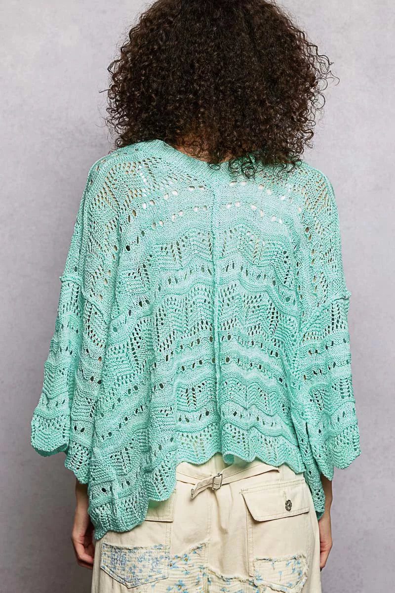 Oversized seafoam green openwork sweater top with V-neck, dropped shoulders, and 3/4 sleeves worn casually