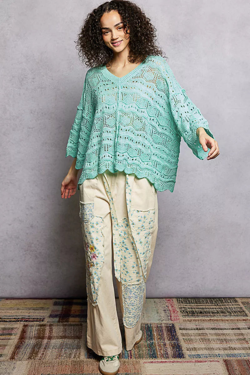 Oversized seafoam green openwork sweater top with V-neck, dropped shoulders, and 3/4 sleeves worn casually