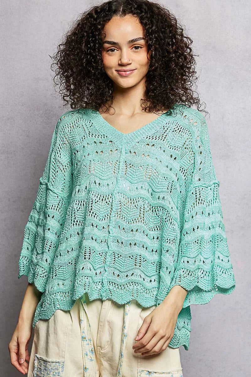 Oversized seafoam green openwork sweater top with V-neck, dropped shoulders, and 3/4 sleeves worn casually